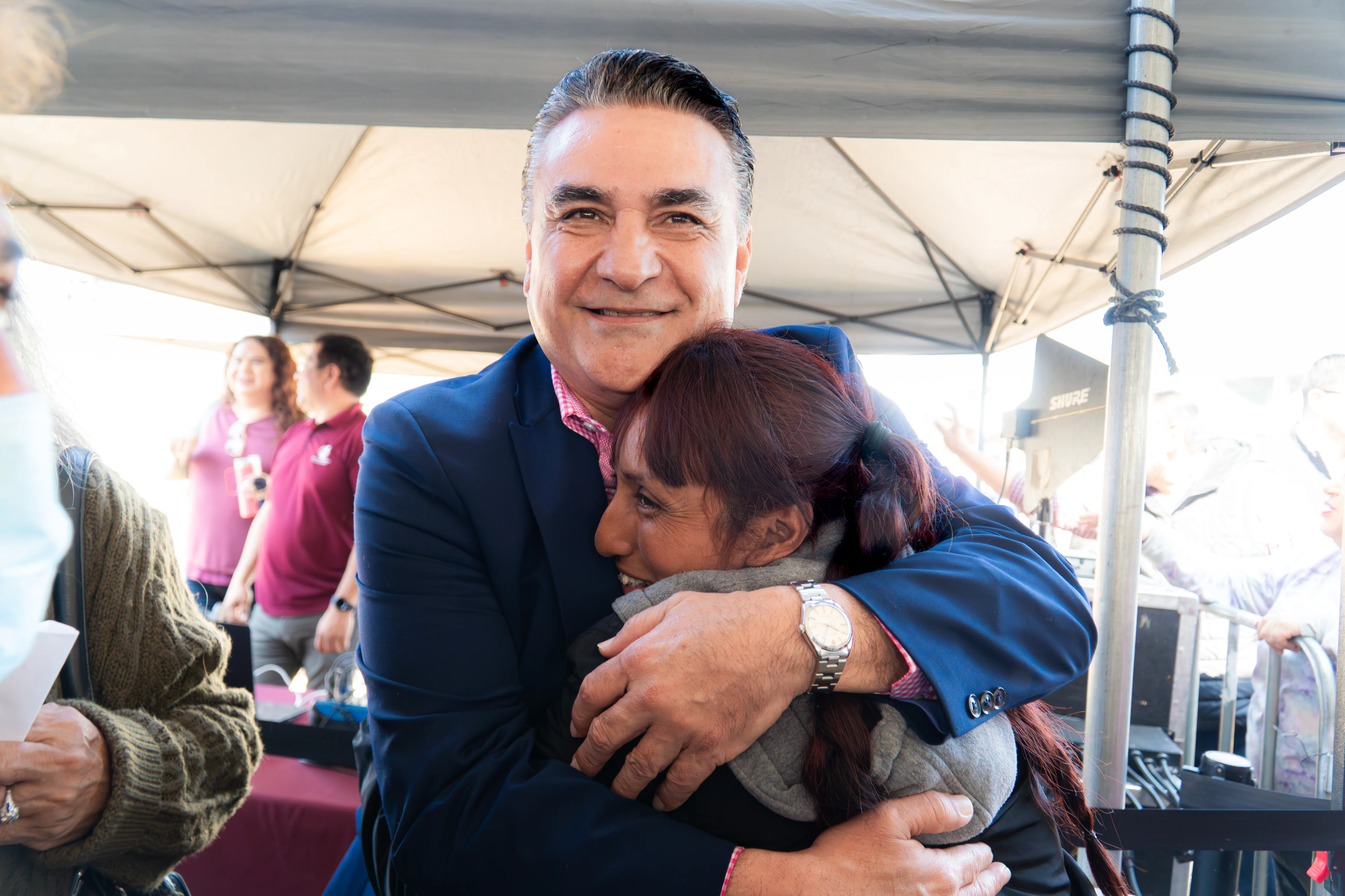 Jesús Ruiz Uribe abrazando afectuosamente a una ciudadana bajacaliforniana