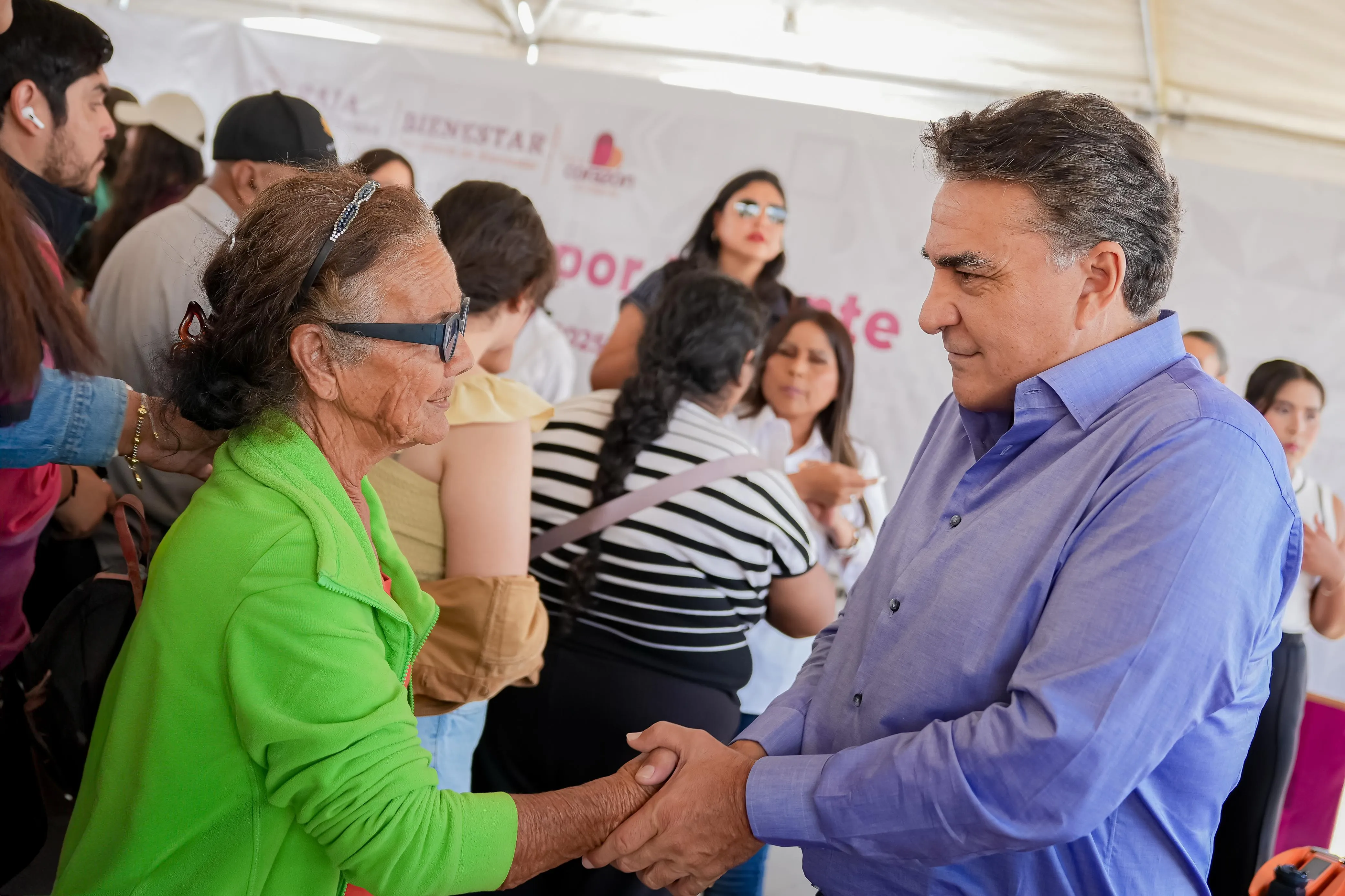 Jesús Ruiz Uribe saludando de mano a una mujer de la comunidad